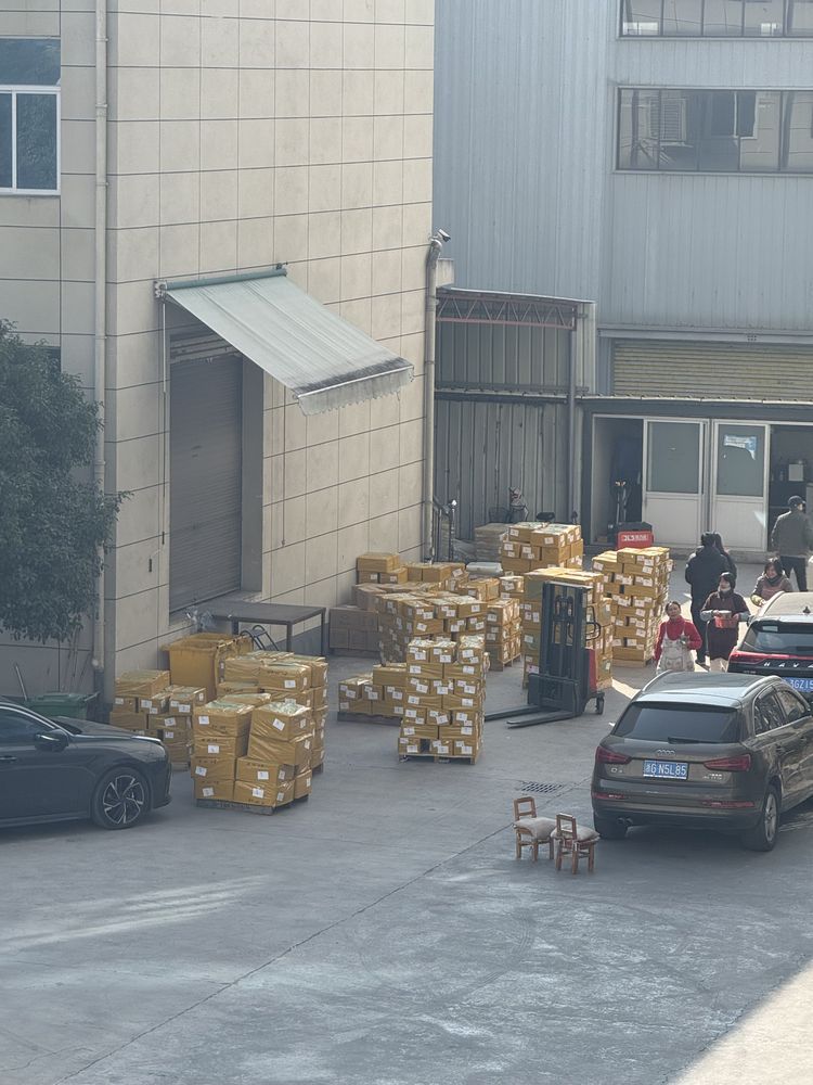 LOCACRYSTAL Pujiang loading yard with sealed yellow cartons of dense small-stone trim ready for export